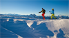 ein paar leute, die auf einem schneebedeckten berg ski fahren